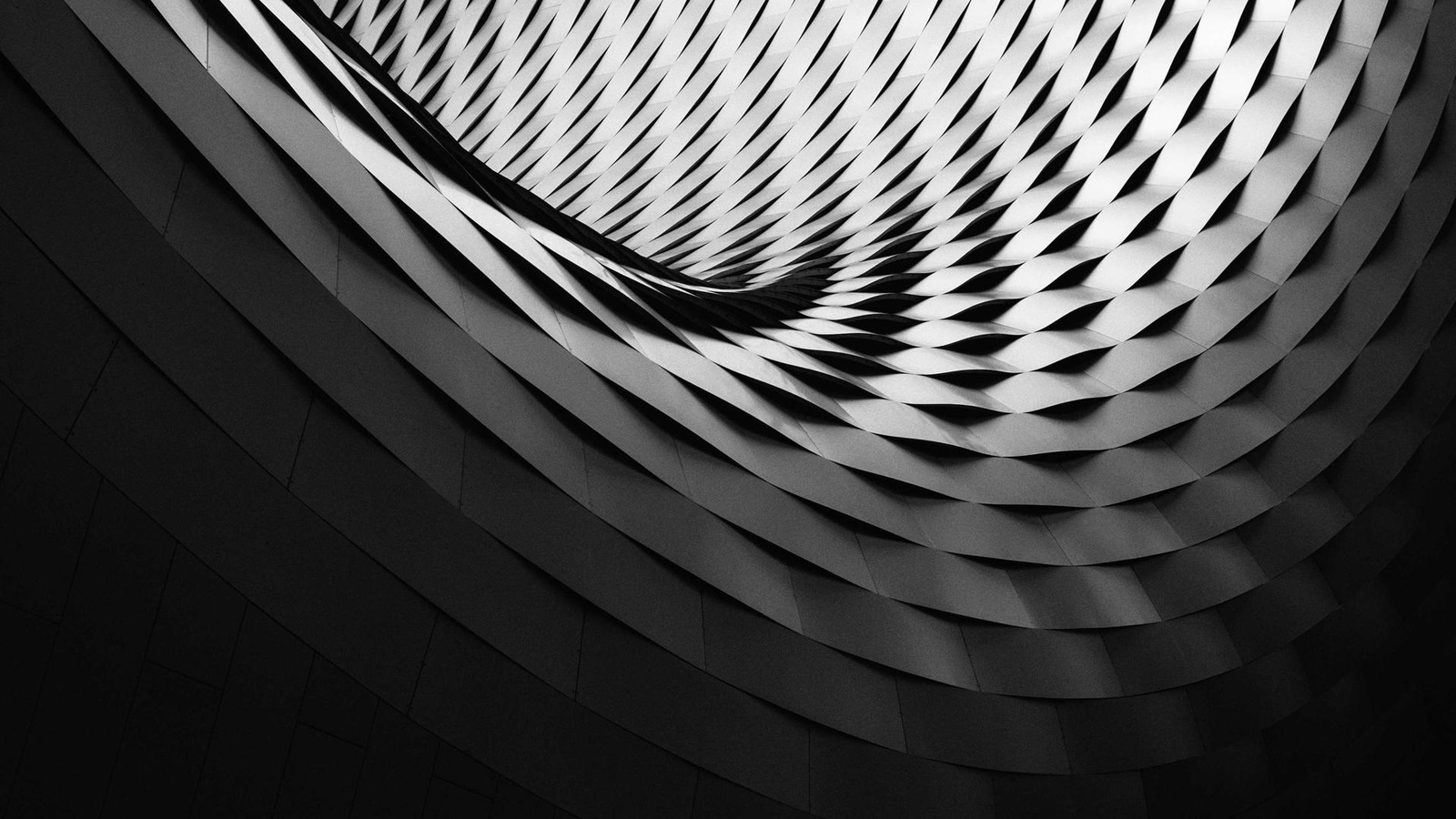 Black-and-white close-up of a repeating curved building facade
